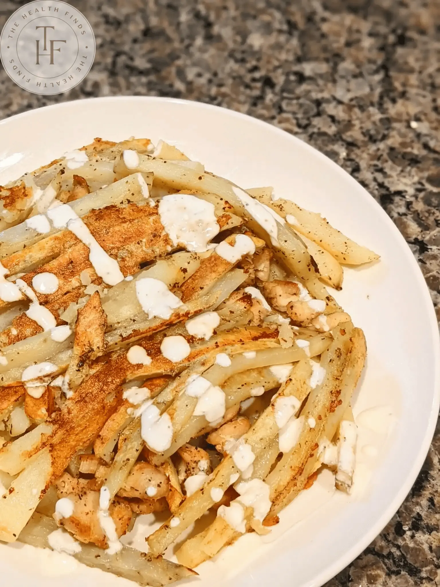 Chicken and fries dribbled with white garlic sauce