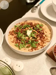 Haleem with fried onions and chopped mint and dollop of ghee